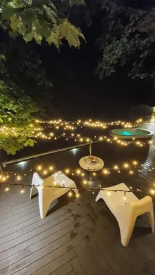 two tables on a deck with lights at night at VIP Red Love house for 2 in Shilagalyay