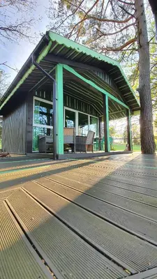 a pavilion with benches on a wooden deck at VIP Yellow dream house Sodyba Geras geltona žalia raudona violetinė in Anykščiai
