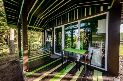 a screened in porch with a green table on it at VIP Yellow dream house Sodyba Geras geltona žalia raudona violetinė in Anykščiai