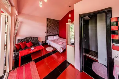 a red living room with a couch and a window at VIP Yellow dream house Sodyba Geras geltona žalia raudona violetinė in Anykščiai