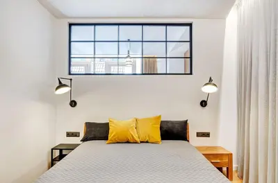 a bedroom with a bed with yellow pillows and a window at Downtown apartment in Vilnius str. in Vilnius