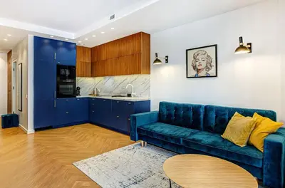 a living room with a blue couch and a kitchen at Downtown apartment in Vilnius str. in Vilnius