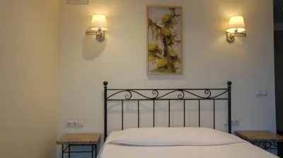a bedroom with a bed and two lights on the wall at Villa Alicante & SPA in Zujūnai