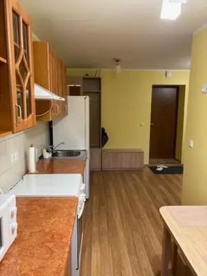a kitchen with wooden floors and a white refrigerator at Jaukus butas in Anykščiai