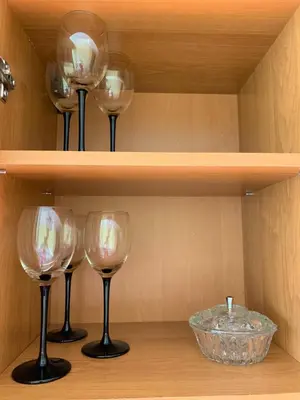 two wine glasses and a bowl on a shelf at Jaukus butas in Anykščiai