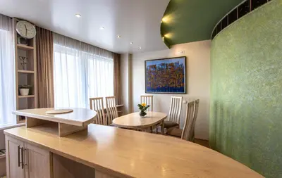 a dining room with two tables and a green wall at Gerda Apartments in Druskininkai