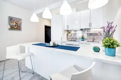 a kitchen with white cabinets and a large white island at HaPPy INN Studio Historic center, Self check-in, AC, Parking in the undergrnd Garage, in Vilnius
