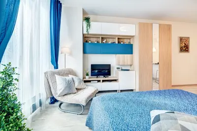 a bedroom with a bed and a chair and a television at HaPPy INN Studio Historic center, Self check-in, AC, Parking in the undergrnd Garage, in Vilnius