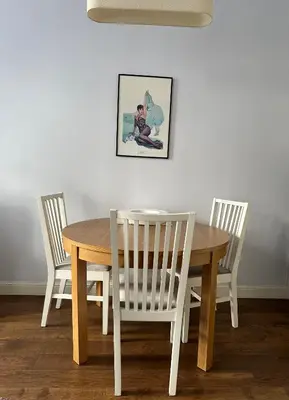 a dining room table and chairs with a table and a picture at Vilnius street apartment in Vilnius