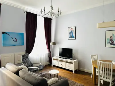 a living room with a couch and a tv at Vilnius street apartment in Vilnius
