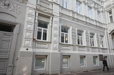 a man walking in front of a building with windows at Vilnius street apartment in Vilnius
