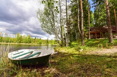 a boat sitting on the shore of a lake at Vidūnų sodyba in Kuktiškės