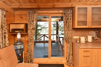 a kitchen with a sliding glass door to a deck at Vidūnų sodyba in Kuktiškės