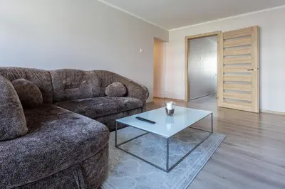 a living room with a couch and a table at Apartamentai Domeva in Druskininkai