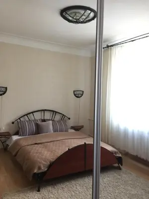 a bedroom with a bed and a large window at Old Town apartament in Šiauliai