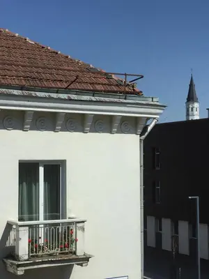 a white building with a balcony on the side of it at Old Town apartament in Šiauliai