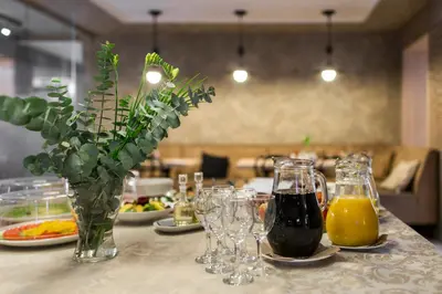 a table with glasses and a vase of orange juice at Big Stone in Ukmergė