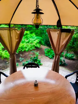 a wooden table with an umbrella and chairs and a tableablish at Prie upes in Kunioniai