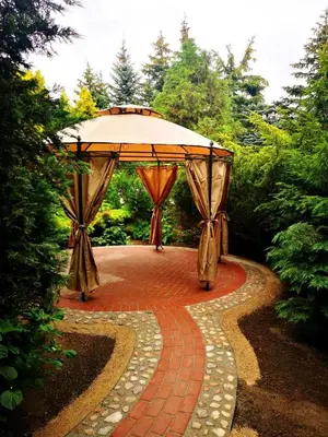 an outdoor pavilion with a canopy and a brick walkway at Prie upes in Kunioniai