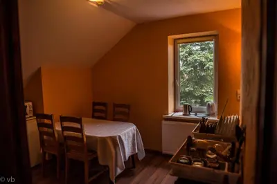a room with a table and chairs and a window at Prie upes in Kunioniai