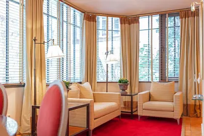 a living room with a couch and chairs and windows at Stikliai Palace Residence in Vilnius