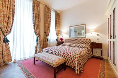 a hotel room with a bed and a chair and windows at Stikliai Palace Residence in Vilnius