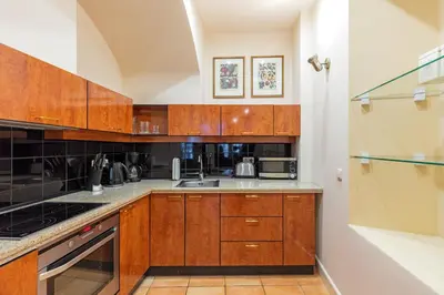 a kitchen with wooden cabinets and a sink at Stikliai Palace Residence in Vilnius