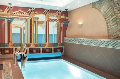 a woman sitting in a pool at a hotel at Stikliai Palace Residence in Vilnius