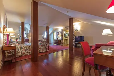 a living room with wooden floors and red chairs at Stikliai Palace Residence in Vilnius