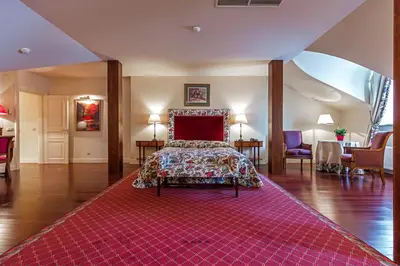 a bedroom with a bed and a red rug at Stikliai Palace Residence in Vilnius