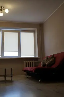 a living room with a couch and two windows at Anyksciu liuksas in Anykščiai