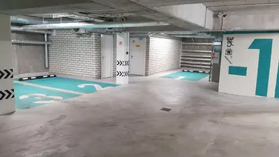 an empty parking garage with blue floors and white walls at HaPPy Inn GOLD Studio, self check-in, Parking in the underground garage in Vilnius
