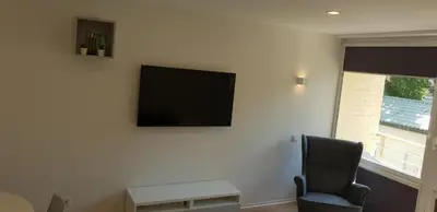a living room with a tv on a white wall at City apartment Anykščiai in Anykščiai