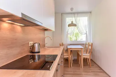 a kitchen with a sink and a table with chairs at Crystal Grey in Druskininkai