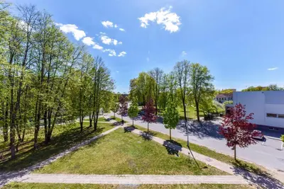 an overhead view of a park with trees and a building at Crystal Grey in Druskininkai