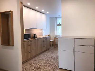 a kitchen with white cabinets and a microwave at Crystal Grey in Druskininkai