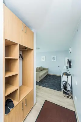 a room with wooden cabinets and a living room at City break. Center in Kaunas
