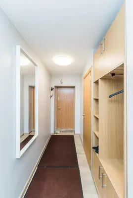 a hallway with wooden cabinets and a door and a hallwayngth at City break. Center in Kaunas