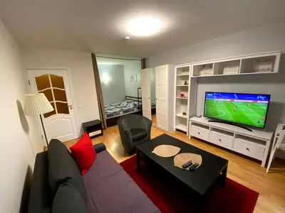 a living room with a couch and a flat screen tv at Your Home - Central studio apartment, balcony, parking & Self Check-in in Vilnius