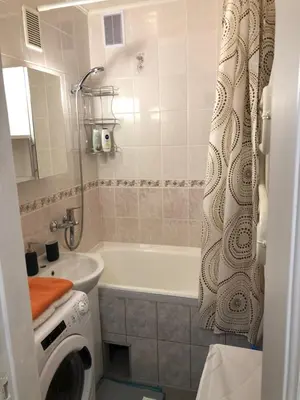 a bathroom with a tub and a sink and a washing machine at Your Home - Central studio apartment, balcony, parking & Self Check-in in Vilnius