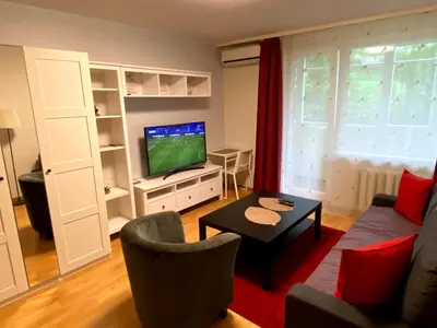 a living room with a couch and a tv at Your Home - Central studio apartment, balcony, parking & Self Check-in in Vilnius