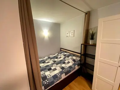 a small bedroom with a bed and a mirror at Your Home - Central studio apartment, balcony, parking & Self Check-in in Vilnius