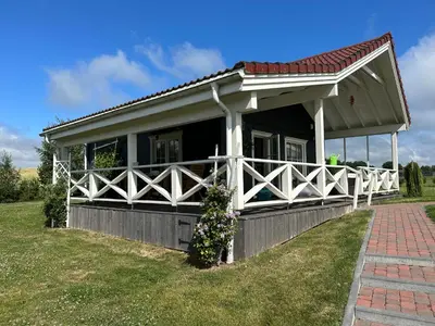 a house with a white fence and a porch at Villa Vita in Seimėnai