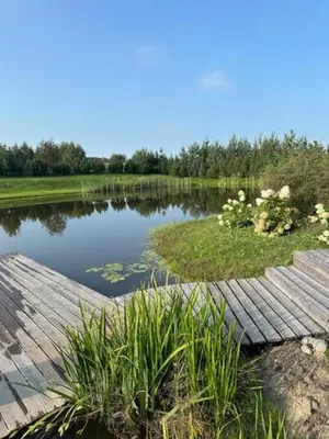 a view of a lake with a wooden deck at Villa Vita in Seimėnai