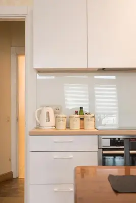 a kitchen with white cabinets and white appliances at M terrace in Kaunas