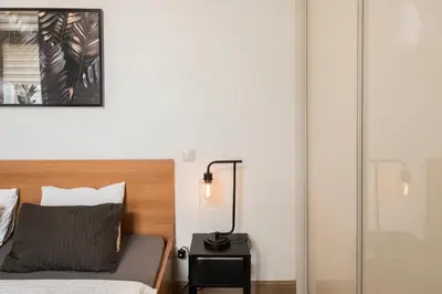 a bedroom with a bed and a lamp on a night stand at M terrace in Kaunas