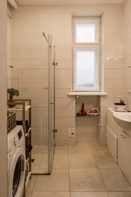 a bathroom with a shower and a sink and a washing machine at M terrace in Kaunas