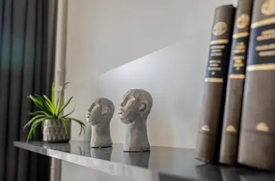 a shelf with two statues on it next to books at Beautiful apartment in the heart of Kaunas in Kaunas