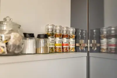 a shelf with spices and other items on it at Beautiful apartment in the heart of Kaunas in Kaunas