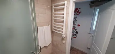 a bathroom with a towel rack and a shower at ApartHotel SAVAS 3 Studio and parking in Kaunas